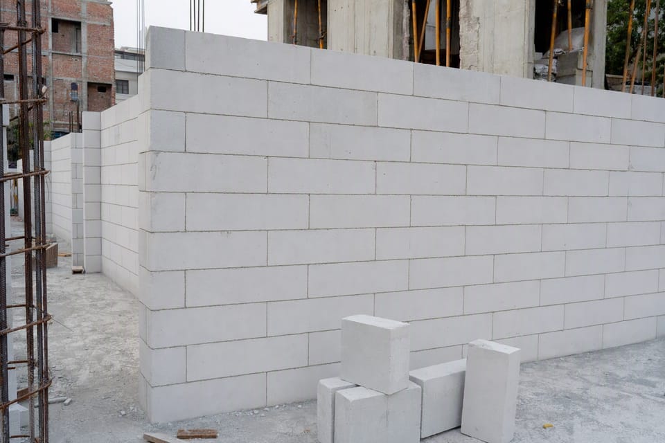 A wall of pale AAC blocks being built with thin even joints