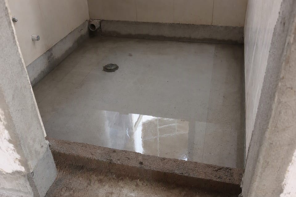 A bathroom floor holding a shallow layer of water for a ponding test