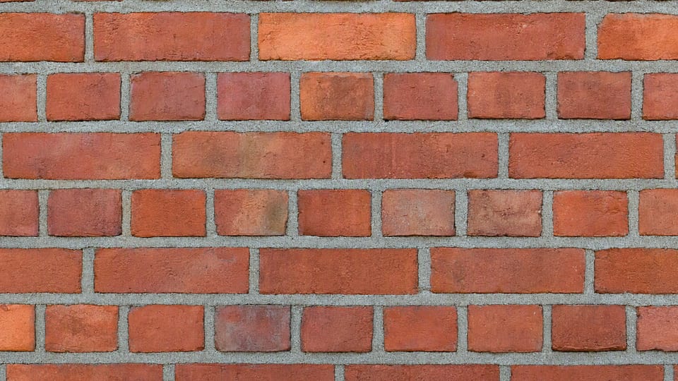 An unplastered red brick wall laid in English bond, with a course of brick ends alternating with a course of long faces