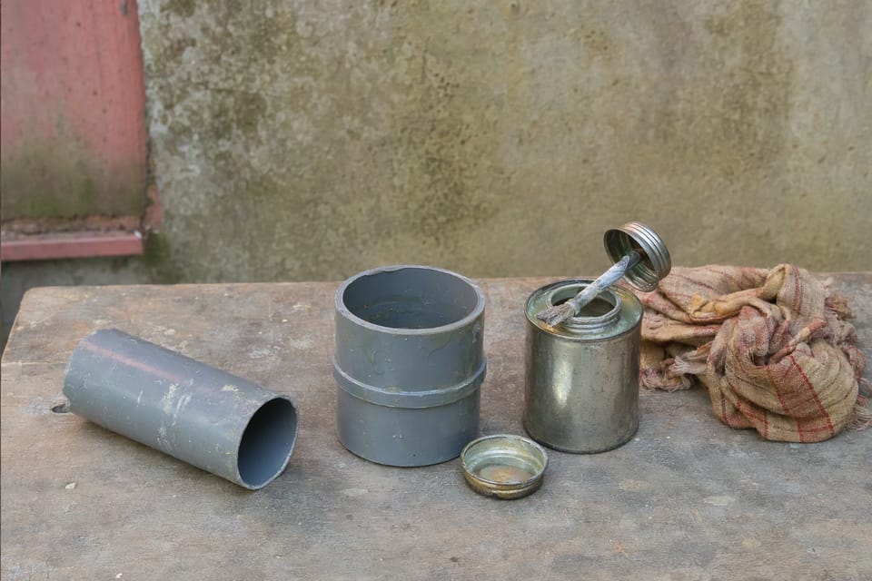 Solvent cement, a socket fitting and a short pipe on a workbench
