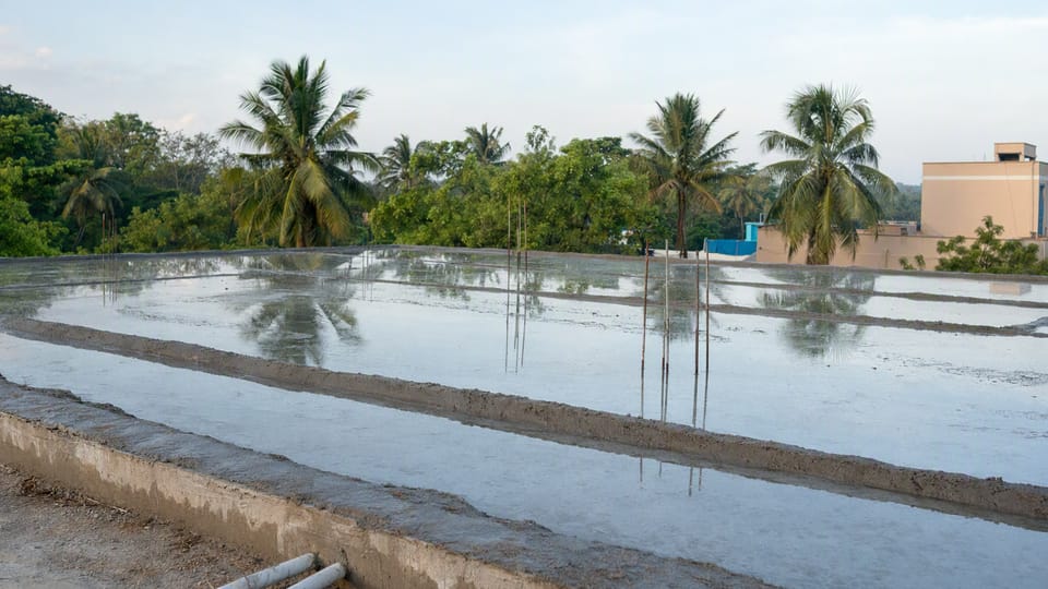 A flat roof slab with shallow water held on its surface for a ponding test